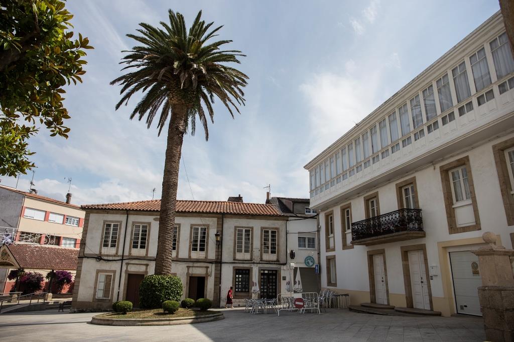 Se encuentra esta plaza ante la iglesia de Santa Marta y el edificio del Concello, en el corazón del casco antiguo.