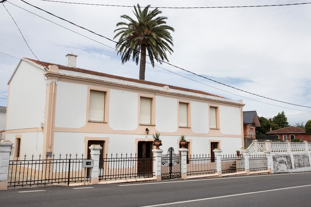 Sencilla casa situada al pie de la carretera que se dirige a Oleiros, a las afueras de Sada. El espacio, de planta rectangular y dos alturas, se abre en la fachada principal con ocho vanos recercados, los de la planta baja con acodos.