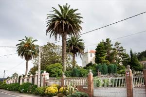 Poco antes del puente de O Pedrido encontramos este suntuoso palacete custodiado por tres palmeras canarias. Separada de la carretera por la amplia finca y un artístico muro, la vivienda se dispone en planta rectangular, sobresaliendo ligeramente de la fachada principal el torreón situado en el ángulo Este.