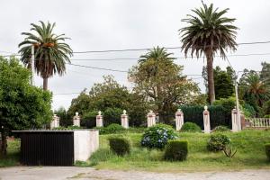 Poco antes del puente de O Pedrido encontramos este suntuoso palacete custodiado por tres palmeras canarias. Separada de la carretera por la amplia finca y un artístico muro, la vivienda se dispone en planta rectangular, sobresaliendo ligeramente de la fachada principal el torreón situado en el ángulo Este.