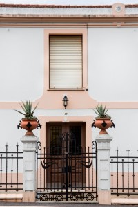 Sencilla casa situada al pie de la carretera que se dirige a Oleiros, a las afueras de Sada. El espacio, de planta rectangular y dos alturas, se abre en la fachada principal con ocho vanos recercados, los de la planta baja con acodos.